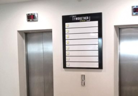panneau positionné entre les ascenseur de l'immeuble de bureaux